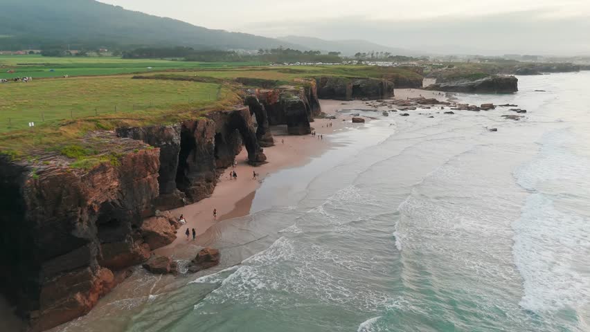 Amazing aerial view of the Playa de Las Catedrales beach in Galicia region at sunset, northern Spain. Beautiful cliff formations on famous Cathedral Beach, Cantabrian Coast 