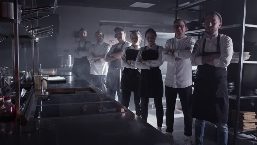 Confident cooks standing with arms crossed in kitchen
