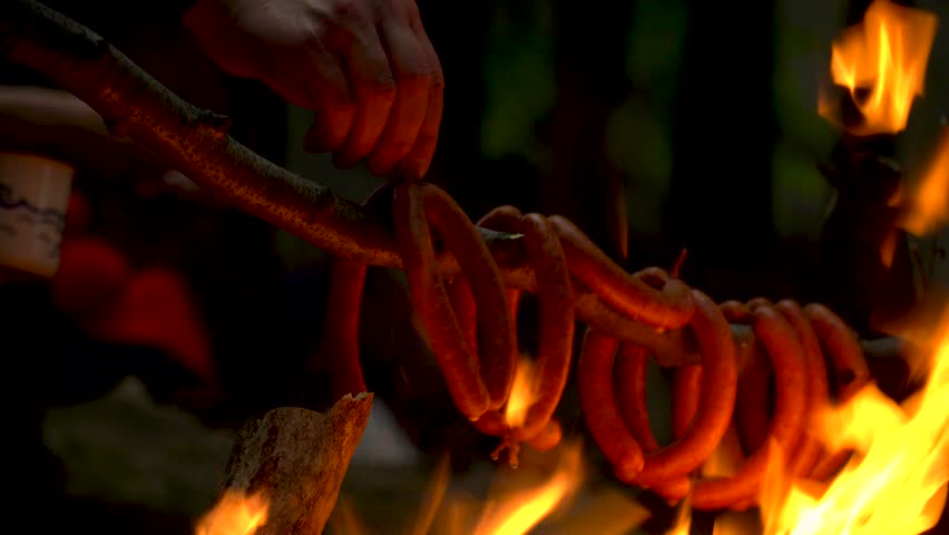 Cooking sausage over open fire