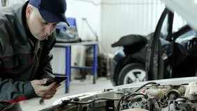 Professional mechanic capturing car engine details using smartphone while performing diagnostic work in modern auto repair workshop - Powered by Shutterstock - Get 15% off with code: PIKWIZARD15