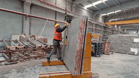 Heavy stone slab transportation in a marble factory. A worker safely positions stone panels with the help of a crane. - Powered by Shutterstock - Get 15% off with code: PIKWIZARD15