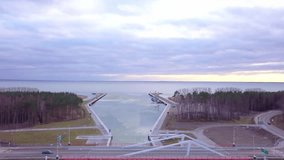 The Vistula Spit canal, seen from above in winter. Ice floes decorate the quiet water, while both the Baltic Sea and Vistula Lagoon stay undisturbed, reflecting the muted afternoon sky. - Powered by Shutterstock - Get 15% off with code: PIKWIZARD15