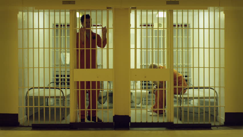 Two prisoners do some exercises in their cells.