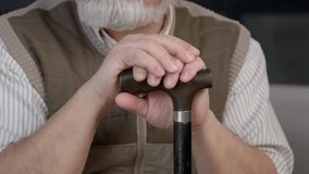 Close-up of senior man on retirement with mobility disability holding curved handle of walking stick, enjoying leisure in care home. - Powered by Shutterstock - Get 15% off with code: PIKWIZARD15
