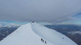 A group of climbers ascends the snowy ridge peak of Mount Elbrus, the highest peak in Europe. The breathtaking view showcases the vast mountain range stretching beyond - Powered by Shutterstock - Get 15% off with code: PIKWIZARD15