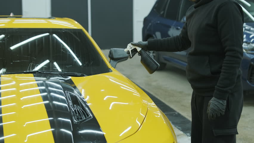Car Detailing Specialist Washing a Yellow Sports Car