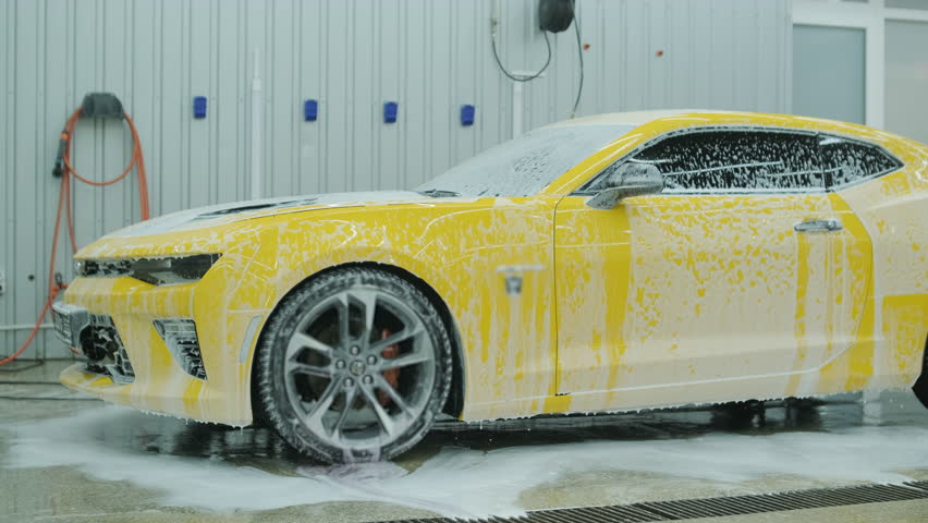 Car Detailing Specialist Washing a Yellow Sports Car