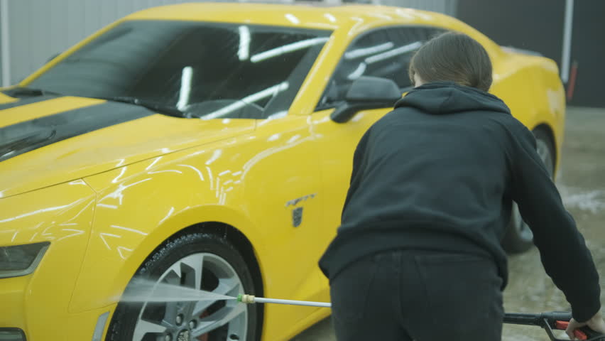 Car Detailing Specialist Washing a Yellow Sports Car