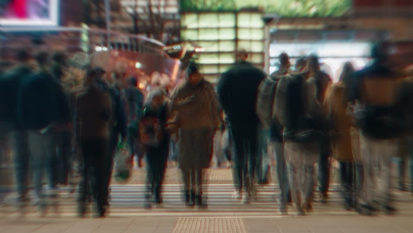 Time-lapse unrecognizable people crowd crossing city street, busy crossroad intersection, blurry pedestrians walking crosswalk in evening. Rush hour many people walk, blurred fast motion at night