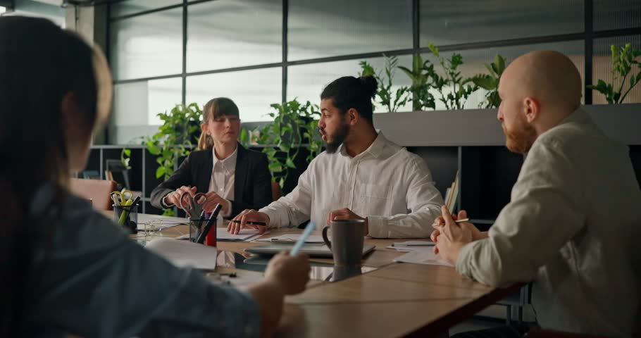 An African office worker shares his idea with colleagues at the table engaging in a discussion to solve problems and find new solutions