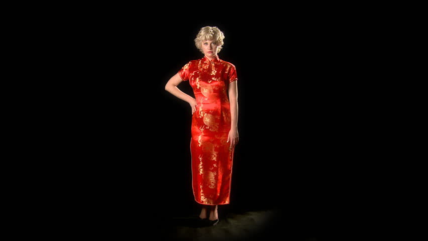 Beautiful blonde poses in red cheongsam (Suzie Wong dress) . Full length shot
