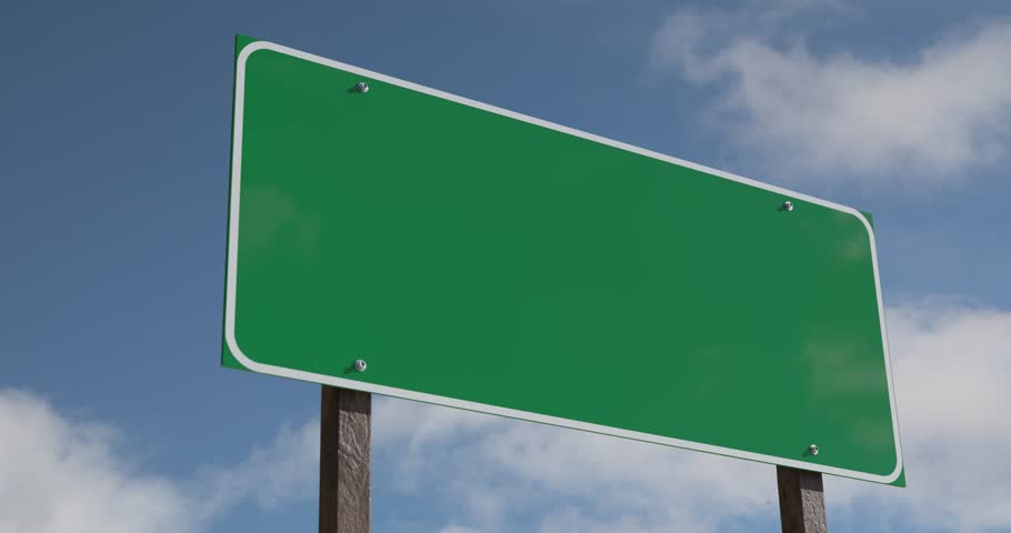 Driving By A Blank Green Road Sign With Clouds and Blue Sky.