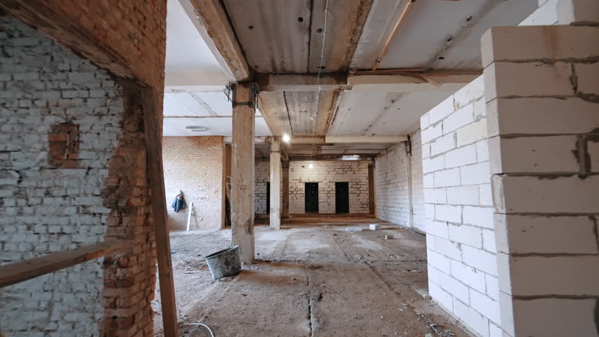 Moving by the corridor with the walls of new and old bricks. Interior of the premise under reconstruction.
