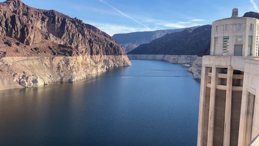 Stunning view of Hoover Dam, the Colorado River, and majestic mountains, all in clear, lovely weather