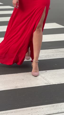 Woman in a red dress walking down a city street. Concept of a city walk.