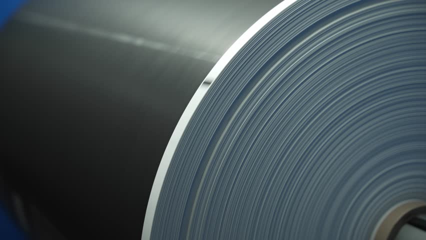 Large roll of printed material in a printing press. Concept of a printing press.