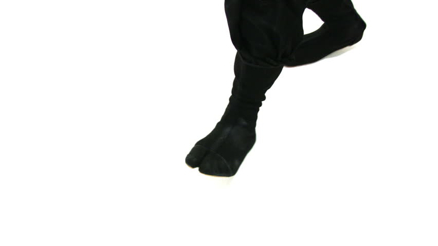 Hand held camera follows ninja feet as they walk on a white background.