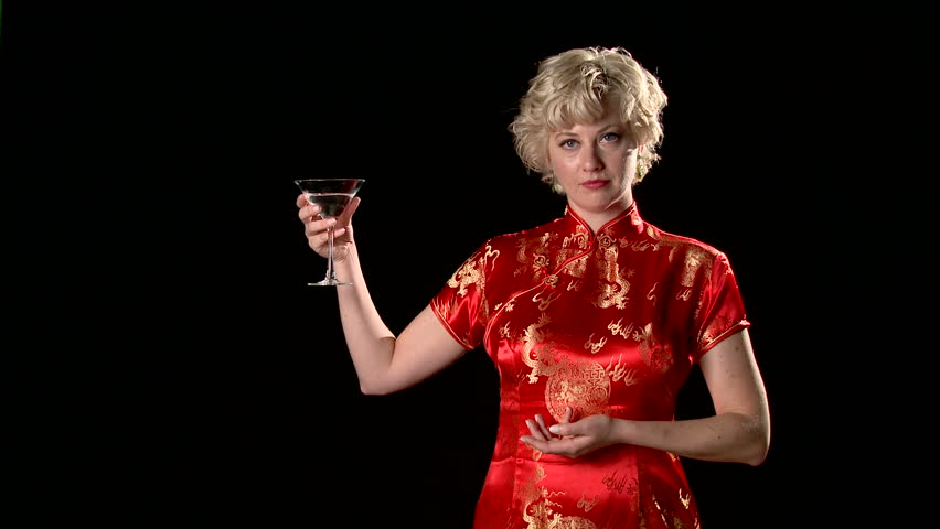 Attractive blonde in red silk oriental dress holds a martini glass, takes a