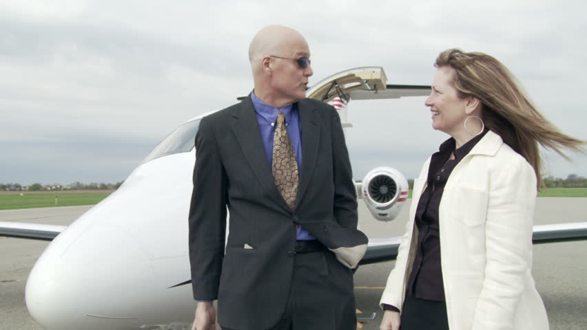 Business man greets a high flying female executive as she arrives on a private