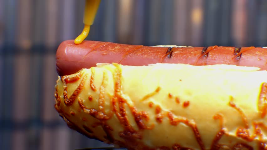 Hot Dog Served Mustard And Ketchup. American Fast Food. Tasty Hot Dog With Grilled Sausage. Appetizing Street Food. Grilled Sausage Hot dog Junk Food. Adding Ketchup And Mustard To Tasty Hot Dog Meat