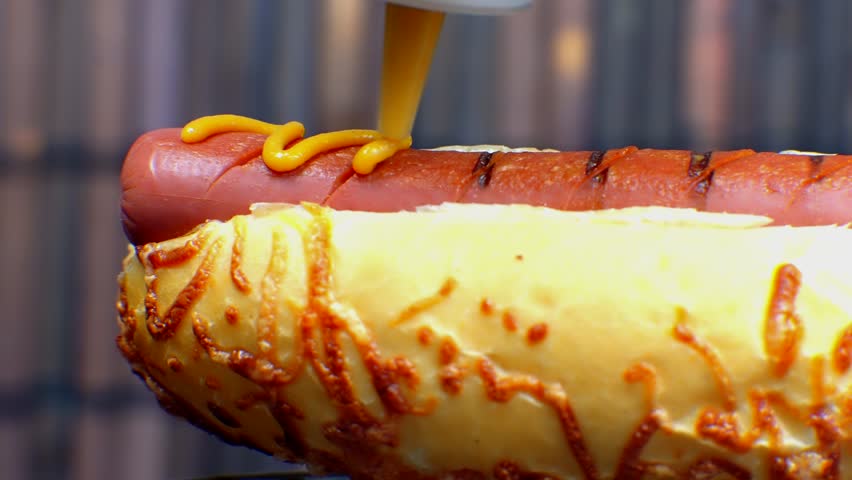 Hot Dog Served Mustard And Ketchup. American Fast Food. Tasty Hot Dog With Grilled Sausage. Appetizing Street Food. Grilled Sausage Hot dog Junk Food. Adding Ketchup And Mustard To Tasty Hot Dog Meat