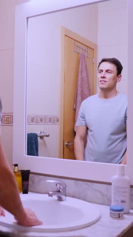Insecure man checking his hair in the mirror