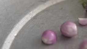 Red onions fall onto the camera in front of the pot and scatter everywhere. - Powered by Shutterstock - Get 15% off with code: PIKWIZARD15