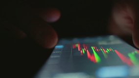 Man reads a stock market chart on his mobile phone while trading online - Powered by Shutterstock - Get 15% off with code: PIKWIZARD15