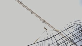 Crane lifts long steel reinforcement bar above rebar framework. Construction site features complex network of metal rods under cloudy sky - Powered by Shutterstock - Get 15% off with code: PIKWIZARD15