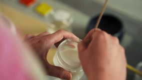 Artist's Hand Stirring Glaze In Small Jar Using Stick. Glazing Clay Cups At Workshop. high angle shot - Powered by Shutterstock - Get 15% off with code: PIKWIZARD15