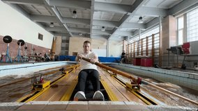 Serious athlete team captain working hard on rowing simulator, breathing heavily. Rowing team concentrating on power technique, endurance, preparing for race, pushing limits for sports success - Powered by Shutterstock - Get 15% off with code: PIKWIZARD15