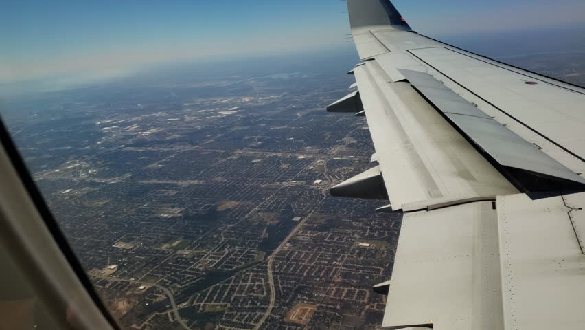 View of large city surrounding area from airplane window. 4k day
