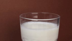 Dropping a chocolate cookie into a glass of milk. Milk splashes in motion, dessert and snack concept. - Powered by Shutterstock - Get 15% off with code: PIKWIZARD15