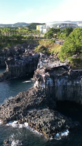 An aerial view of the Daepo Jusangjeolli Cliff in Seogwipo city at the southern coast of Jeju Island, South Korea, on a sunny day