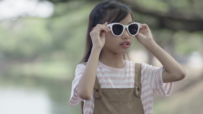 A little girl is wearing sunglasses to protect her eyes.