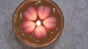 Beautiful gel candle with burning wick and pink wax heart decorations - Powered by Shutterstock - Get 15% off with code: PIKWIZARD15