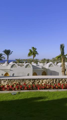 Panoramic video view of a Luxury hotel resort from the nice terrace with palm trees, mountains, oriental architecture. Sunny vacations in Egypt