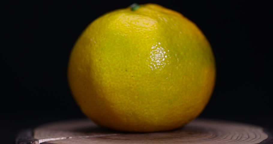 one green tangerine with a green peel , one ripe tangerine but with an orange green peel
