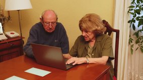 Senior couple browsing internet on laptop, happy and smiling, enjoying technology in their home - Powered by Shutterstock - Get 15% off with code: PIKWIZARD15