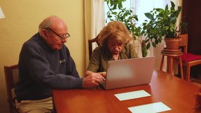 Senior couple browsing internet on laptop, happy and smiling, enjoying technology in their home - Powered by Shutterstock - Get 15% off with code: PIKWIZARD15