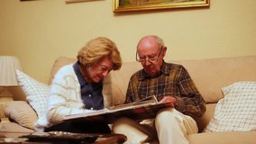 Happy retired couple enjoying their free time together, browsing through old photographs and reminiscing about past memories - Powered by Shutterstock - Get 15% off with code: PIKWIZARD15