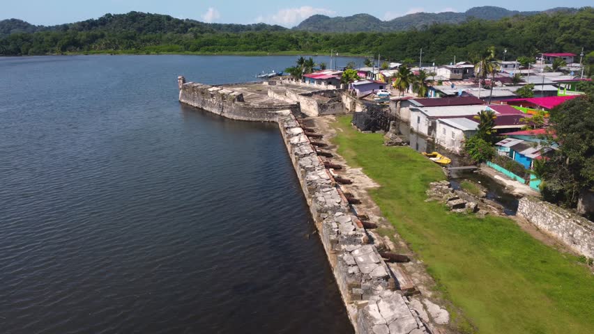 Portobelo, Panamá. March 17 of 2025. You can see the walls and canons of the ancient Spanish colonial settlement of "Fuerte San Jerónimo" in Portobelo. Aerial 4k drone shot. You an see fishing boats.