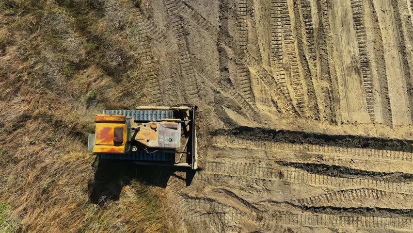 construction work of bulldozer during road construction. Large bulldozers level the sandy base. Epic footage of large construction equipment working. drone view of road construction. Overhead shot 