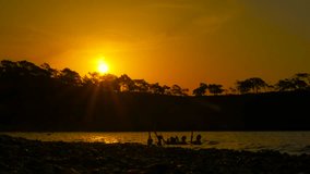 Friends enjoying refreshing sunset swim together. Silhouetted friends are waist-deep in water, playfully splashing and enjoying the warm glow of the setting sun over the shore - Powered by Shutterstock - Get 15% off with code: PIKWIZARD15