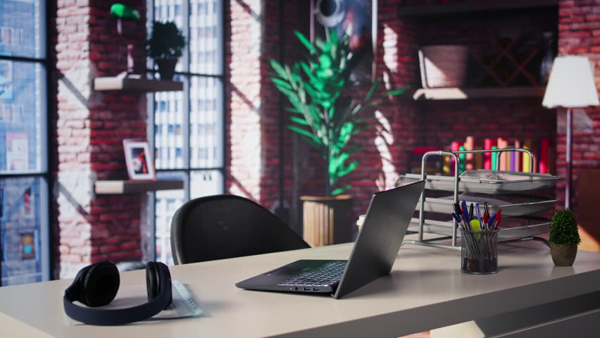 Clean open desk in a luxurious home office loft surrounded by panoramic windows and sleek furniture, the modern design creates a spacious artistic ambiance perfect for work and creativity.