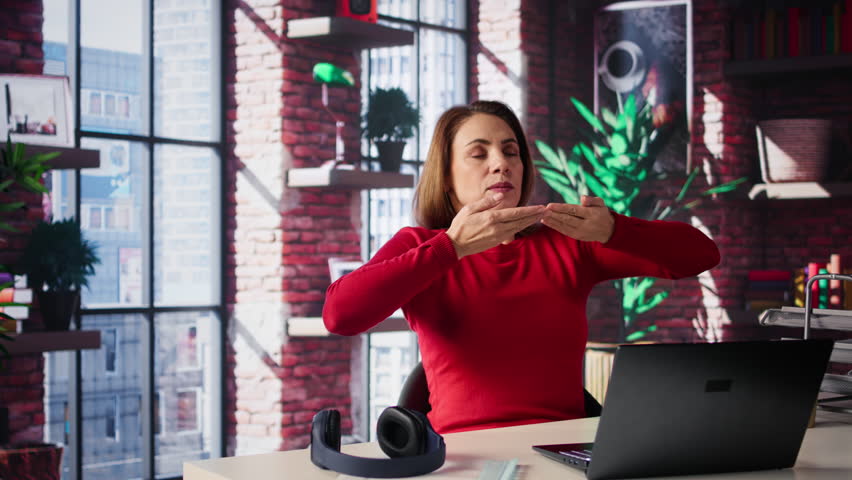 Mature woman takes a deep breath and grounding herself in her apartment, soothing and building his energy with meditation. Person with calmness and self care improves her focus. Camera B.