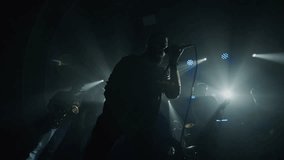 Energetic singer captivating audience with powerful performance under bright stage lights, shot in slow motion - Powered by Shutterstock - Get 15% off with code: PIKWIZARD15