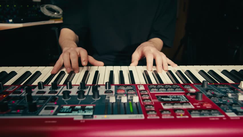 Close Up of keyboard Player Hands Playing Rock Music with keyboard at the Concert in studio, rehearsal room, macro play on synthesizer.