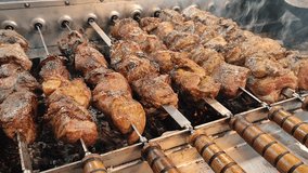 Frying shashlik. Grilling kebabs on mangal. Pieces meat roasting on rotating skewers over coals. Delicious grilled meat on spinning skewer. Cooking meat food BBQ outdoors. Cooking street food barbecue - Powered by Shutterstock - Get 15% off with code: PIKWIZARD15