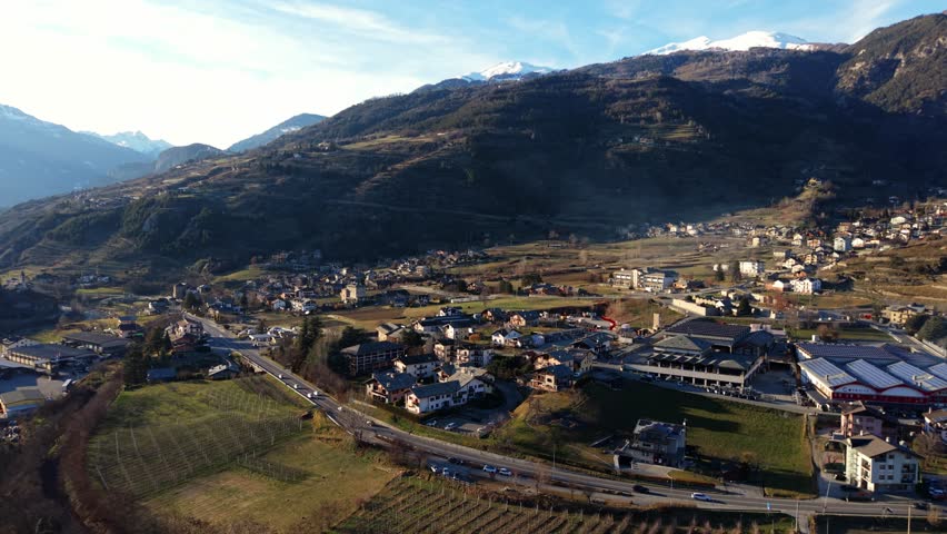 A peaceful village in valle d'aosta, italy, surrounded by snow-capped mountains, aerial view